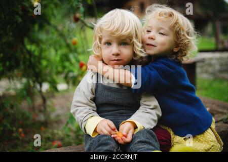 Kleine Kinder sitzen im Garten, nachhaltiges Lifestyle-Konzept. Stockfoto