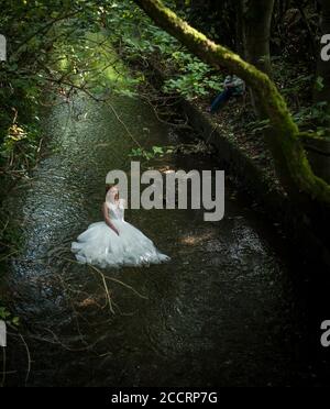 Braut im Hochzeitskleid in Fluss Redhead Stockfoto