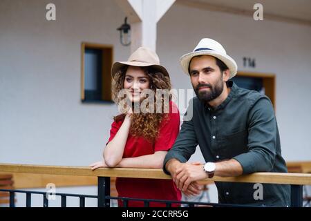 Junges Paar, das im Urlaub im Freien bei Hotel steht, entspannt. Stockfoto
