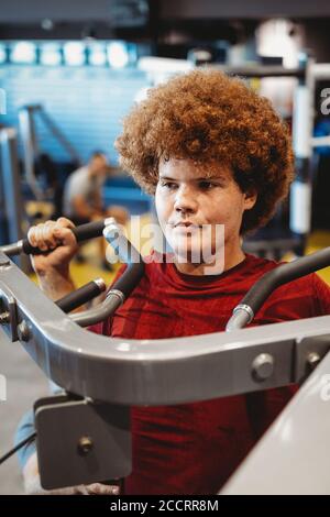 Übergewichtiger junger Mann, der in der Sporthalle trainiert, um Ziele zu erreichen Stockfoto