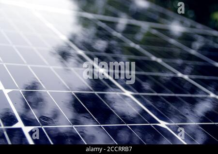 Nasse Solarzellen auf dem Dach. Photovoltaik zu Hause im Regen. Stockfoto