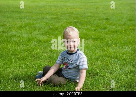 Zweijähriger Junge, der auf einem Rasen in Janowiec, Woiwodschaft Lublin, Polen spielt Stockfoto