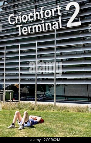 Neues Terminal 2, T2 Criochfort Dublin International Airport DUB. Junger Mann in Shorts, ruht, auf dem Gras liegend. Republik Irland, Europa, EU. Stockfoto