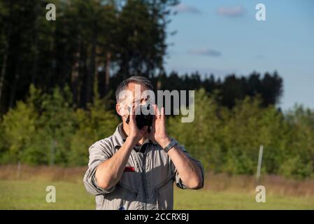 Tanne, Deutschland. Juli 2020. Winfried Borchert, Pilot und Betreiber des Brocken-Ballons, gibt seinen Passagieren Anweisungen. Er trägt eine schwarze Maske als Schutz vor einer Coronainfektion. Quelle: Stephan Schulz/dpa-Zentralbild/ZB/dpa/Alamy Live News Stockfoto