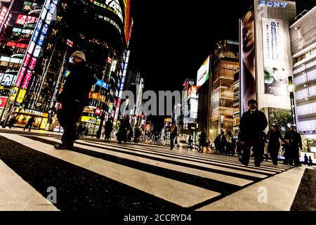 Tokyo, Japan - 14. Januar 2010: Fußgänger überqueren der Straße im Herzen von Ginza in Tokio. Ginza Kreuzung bei Nacht. Verschwommene Bewegung. Stockfoto