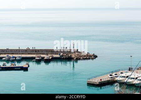 Antalya, Türkei - 22. Februar 2019: Touristenyacht am Pier in der Nähe des Leuchtturms im Hafen in der Altstadt von Kaleici in Antalya. Stockfoto