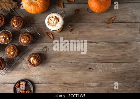 Herbstfrühstück. Hausgemachte Kürbis Gewürz Latte und Kürbis Muffins mit gesalzenem Karamell und Pekannüssen, Draufsicht, Kopierraum. Herbstsaison Dessert Kontra Stockfoto