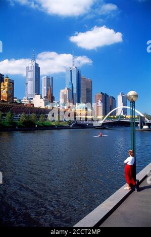 Lady mit Blick auf die Skyline der Innenstadt mit Brücke über den Yarra River von Melbourne aus. Victoria, Australien Stockfoto