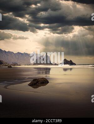 Schöne Aufnahme von Sonnenstrahlen fallen auf das Meer Wasser aus Düstere Wolken Stockfoto