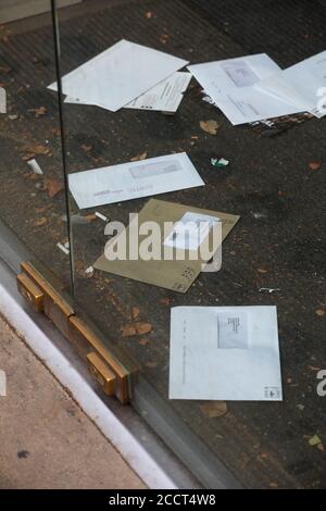 Briefe und Rechnungen stapeln sich auf der Türmatte eines geschlossenen Ladens an der Brompton Road, London, Großbritannien. Stockfoto