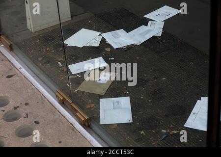 Briefe und Rechnungen stapeln sich auf der Türmatte eines geschlossenen Ladens an der Brompton Road, London, Großbritannien. Stockfoto