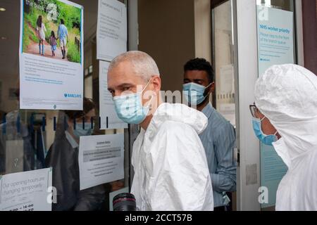 London, Großbritannien. August 2020. Mitglieder der Extinction Rebellion, die in sauberen Anzügen gekleidet sind, interagieren mit Barclays Mitarbeitern in Balham, South London. XR-Kontakt Stockfoto
