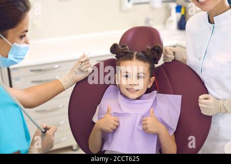 Glücklich Kind Mädchen zeigt super in Zahnarztpraxis. Kinderzahnarzt Kieferorthopäde. Stockfoto