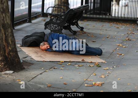 Ein obdachloser Mann, der auf der Brompton Road, London, Großbritannien, schlecht schläft. Stockfoto