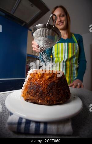 Frau mit einem Gugelhupf in einer Küche Stockfoto