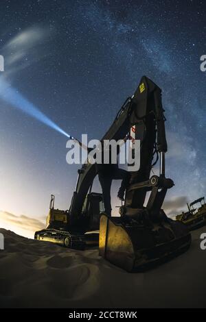 Bagger arbeiten unter dem Nachthimmel mit der Milchstraße in Valdevaqueros, Cadiz, Andalusien Stockfoto