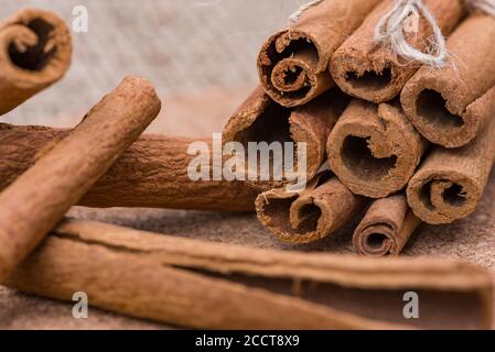 Zimtstangen, trockene Zimtrinde in einem Bündel auf einem Sackleinen Hintergrund gebunden. Stockfoto