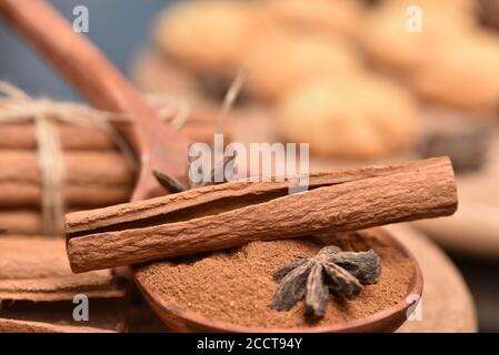 Traditionelle Weihnachtsgewürze - Sternanis mit Zimt und Nelken auf dunklem rustikalem Holzhintergrund Zimtrinde und Hammer und Kekse. Stockfoto