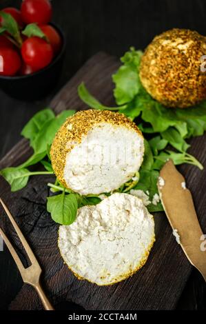 Kleine Bälle aus Schweizer Hartkäse Belper Knolle, hergestellt aus Kuhmilch. Ein frisch geschnittener Käseball liegt auf einem schönen antiken Holzbrett mit antik Stockfoto