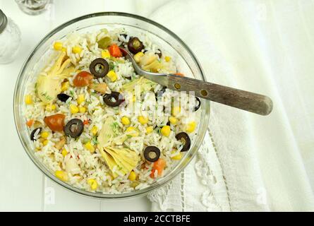Sommerliches Food-Konzept. Frischer Reissalat mit gemischtem Gemüse in einer Glasschüssel isoliert auf weißem Hintergrund. Draufsicht. Stockfoto