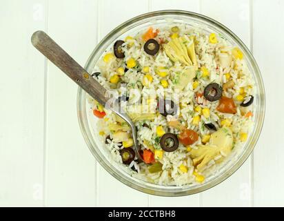 Sommerliches Food-Konzept. Frischer Reissalat mit gemischtem Gemüse in einer Glasschüssel isoliert auf weißem Hintergrund. Draufsicht. Stockfoto