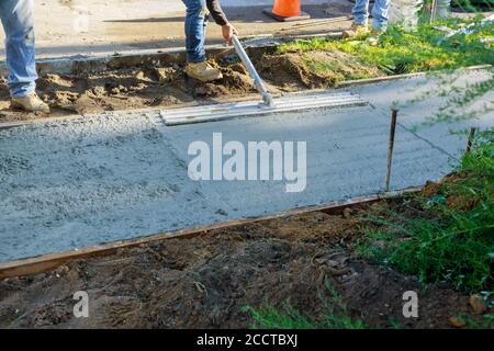 Baumörtel Bau einer Estrich Zement ein Arbeiter schwimmt einen neuen Betonweg Stockfoto