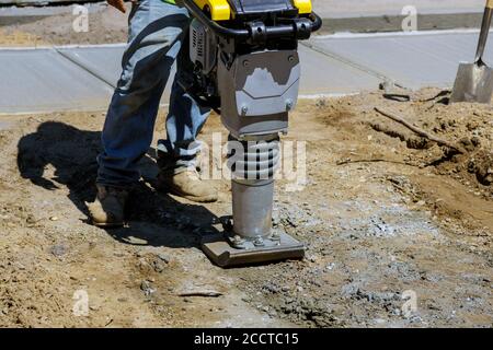 Bauarbeiten am Bürgersteig Montage des Schwinghammer Kraftwerkzeugs am Boden beim Bau Stockfoto