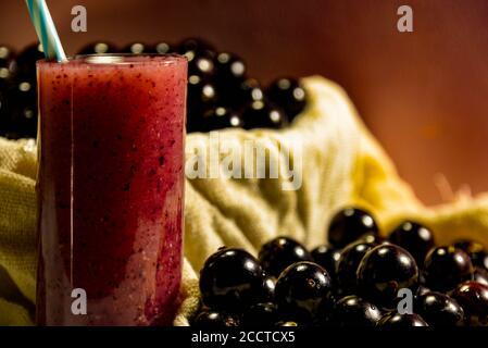 Frisches Obst und ein Glas Jaboticaba Saft. Jabuticaba ist eine Frucht, die ursprünglich aus Brasilien stammt. Sie ist im Atlantischen Wald beheimatet und hat die ungewöhnlichen Eigenschaften Stockfoto