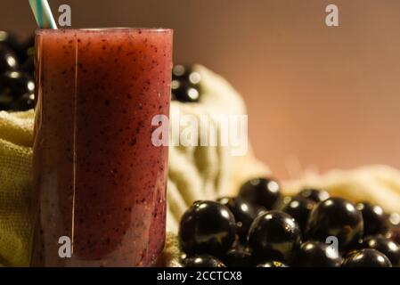 Frisches Obst und ein Glas Jaboticaba Saft. Jabuticaba ist eine Frucht, die ursprünglich aus Brasilien stammt. Sie ist im Atlantischen Wald beheimatet und hat die ungewöhnlichen Eigenschaften Stockfoto