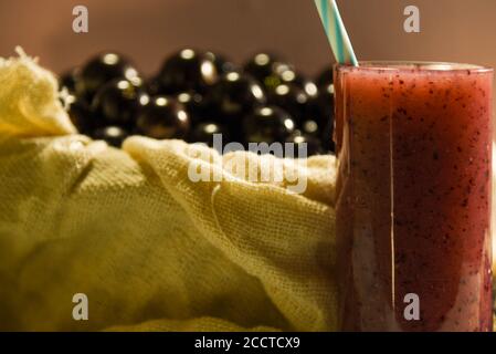 Frisches Obst und ein Glas Jaboticaba Saft. Jabuticaba ist eine Frucht, die ursprünglich aus Brasilien stammt. Sie ist im Atlantischen Wald beheimatet und hat die ungewöhnlichen Eigenschaften Stockfoto