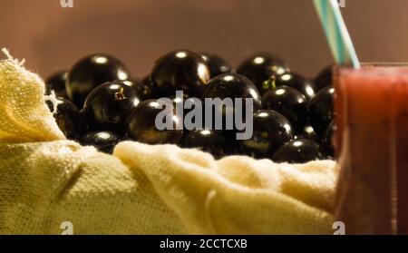 Frisches Obst und ein Glas Jaboticaba Saft. Jabuticaba ist eine Frucht, die ursprünglich aus Brasilien stammt. Sie ist im Atlantischen Wald beheimatet und hat die ungewöhnlichen Eigenschaften Stockfoto