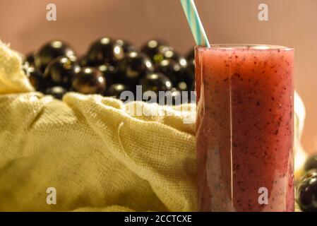 Frisches Obst und ein Glas Jaboticaba Saft. Jabuticaba ist eine Frucht, die ursprünglich aus Brasilien stammt. Sie ist im Atlantischen Wald beheimatet und hat die ungewöhnlichen Eigenschaften Stockfoto