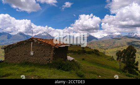 Rustikale Hütte in einem schönen Hügel mit den Anden auf Hintergrund Stockfoto