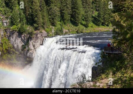 Ein Regenbogen im Nebel der Upper Mesa Falls Es stürzt über eine Klippe in die zerklüftete Wildnis von Henrys Fork des Snake River entlang der Mesa Falls Stockfoto