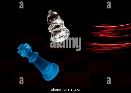 Schachfiguren bewegen sich mit Farbefekten aus verschiedenen Lichtern Stockfoto