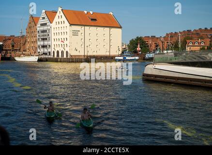 Danzig, Nordpolen - 13. August 2020: Weitwinkelaufnahme des Sommers und Menschen Kajakfahren in motlawa Fluss angrenzend an schöne europäische Architektur nea Stockfoto