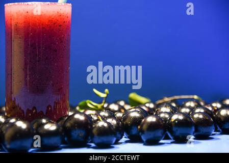 Saft und Früchte von Jaboticaba (Myrciaria cauliflora). Die jabuticaba hat eine abgerundete Form und eine dunkelviolette Farbe. Sein weißes Fruchtfleisch hat sehr wenige Samen a Stockfoto