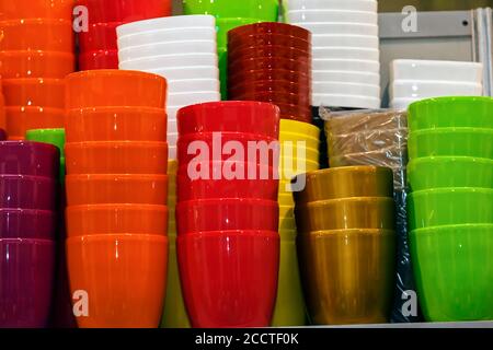 Blumentöpfe aus Kunststoff in verschiedenen Farben auf den Regalen Stockfoto