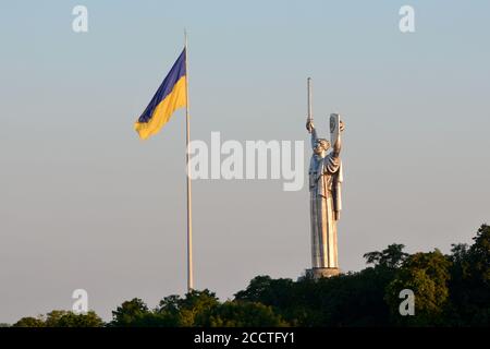 Kiew, Ukraine. August 2020. Die größte Flagge der Ukraine fliegt etwa 90 Meter über der Stadt, wie sie am Vorabend des Tages der Staatsflagge angebracht wurde, mit dem Mutterlanddenkmal im Zentrum von Kiew, Ukraine am 23. August 2020. Die Ukraine markiert den Tag der Staatsflagge am 23. August und den Tag der Unabhängigkeit am 24. August. (Foto: Aleksandr Gusev/Pacific Press/Sipa USA) Quelle: SIPA USA/Alamy Live News Stockfoto