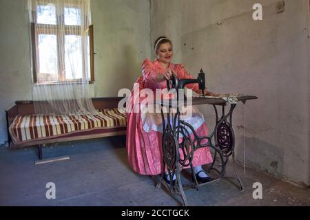 Ivanovo, Serbien, 09. April 2017. Ein Mädchen in einem Raum sitzt hinter einer Nähmaschine und näht. Stockfoto