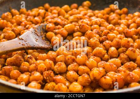 Kochen Kichererbsen mit Gewürzen in einer Pfanne, Nahaufnahme Stockfoto