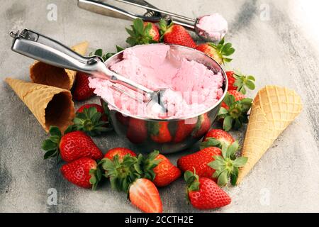 Strawberry Ice Cream scoop mit frischen Erdbeeren und Eiscreme Kegel auf einem urigen Hintergrund Stockfoto