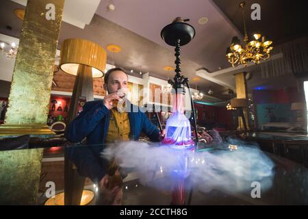 Raucher Shisha. Mann bläst Rauch in einem Café. Stockfoto