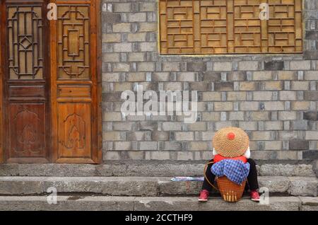 Fenghuang, China - 15. Mai 2017: Frau rast auf der Straße in der Stadt Phoenix Fenghuang Stockfoto