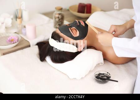 Gesicht peeling Maske, Wellness Schönheitspflege, Hautpflege. Frau erhalten Gesichtspflege von kosmetikerin in Spa Salon, Seitenansicht, close-up Stockfoto