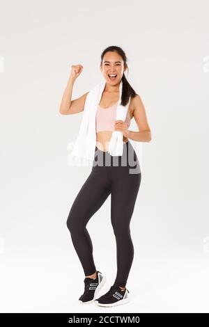 Sport, Fitness und gesundes Körperkonzept. Volle Länge der ermutigt und motiviert asiatische Brünette Mädchen bereit für Fitness-Training, Faust Pumpe und schreien in Stockfoto