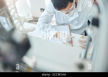 Männlicher Wissenschaftler, der mit einer Testprobe arbeitet Stockfoto
