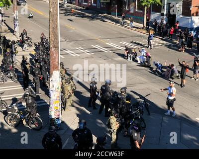 USA 25. Juli 2020: Spät am Tag protestierende Demonstranten, die auf der Polizeilinie auf dem Capitol Hill knieten. Stockfoto