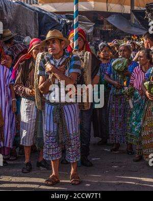 Ein Tzutuji Maya Mann in der traditionellen Kleidung von Santiago trägt eine Trommel in der Prozession der Fiesta von Santiago, der schutzpatron von Santiago Atit Stockfoto