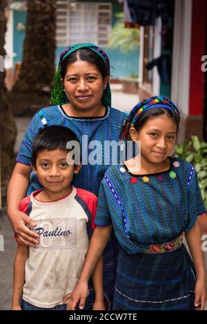 Eine Cakchiquel Maya-Frau in traditioneller Kleidung aus San Antonio Palopo, Guatemala, mit ihren Kindern. Ihre blau gewebte Huipil-Bluse ist charakteristisch o Stockfoto